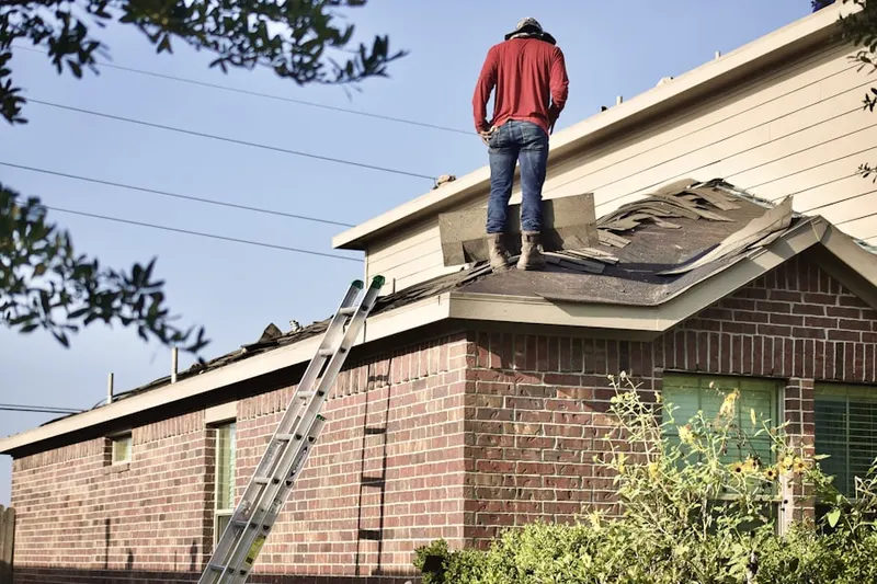 Professional roofer working on a residential roof in Mission Hills Country Club